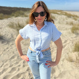 Musselinbluse in cropped Schnitt zum binden. Die Bluse hat kurze Flügelärmel und ist babyblau.