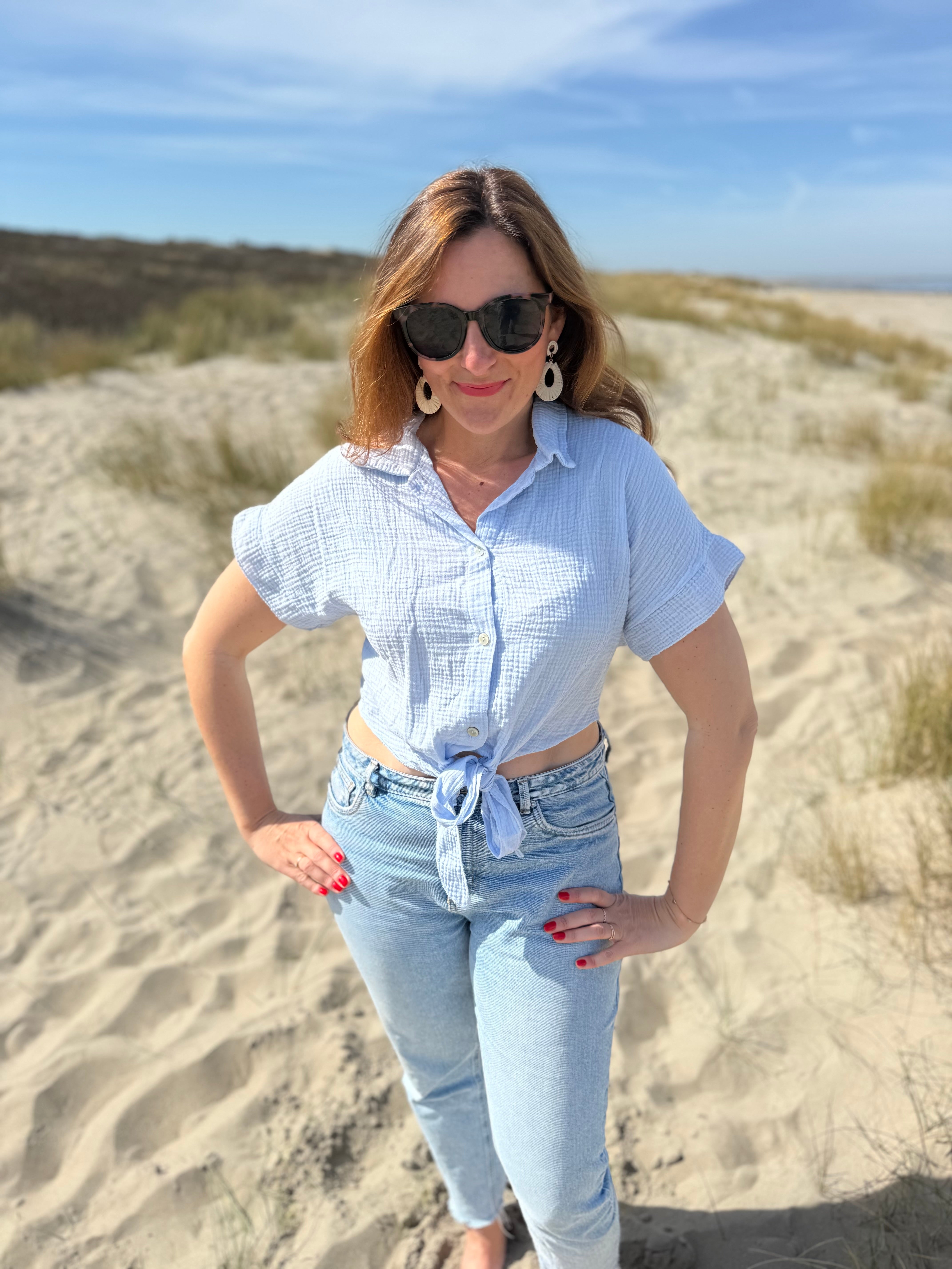 Musselinbluse in cropped Schnitt zum binden. Die Bluse hat kurze Flügelärmel und ist babyblau.