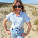 Musselinbluse in cropped Schnitt zum binden. Die Bluse hat kurze Flügelärmel und ist babyblau.