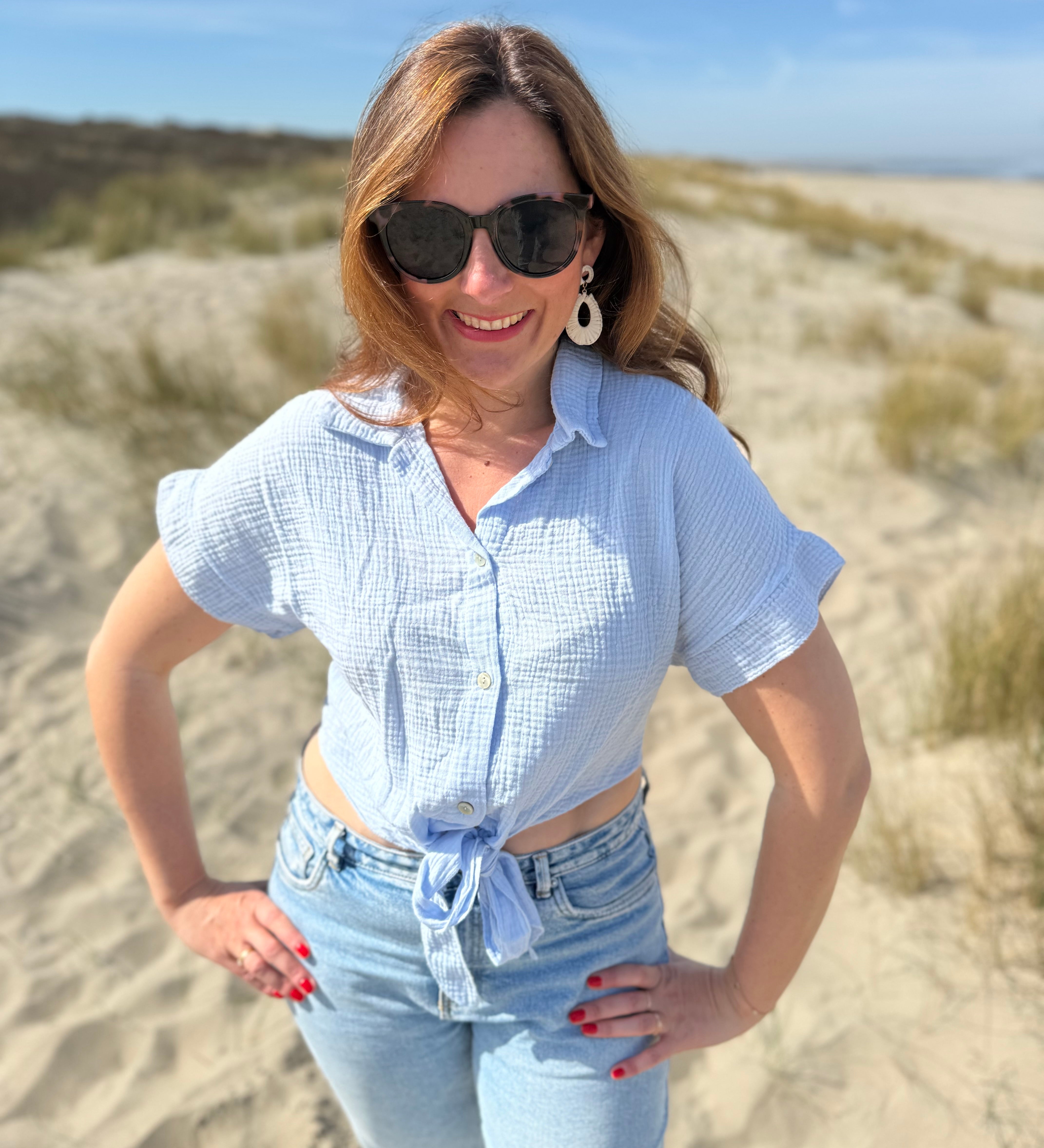 Musselinbluse in cropped Schnitt zum binden. Die Bluse hat kurze Flügelärmel und ist babyblau.