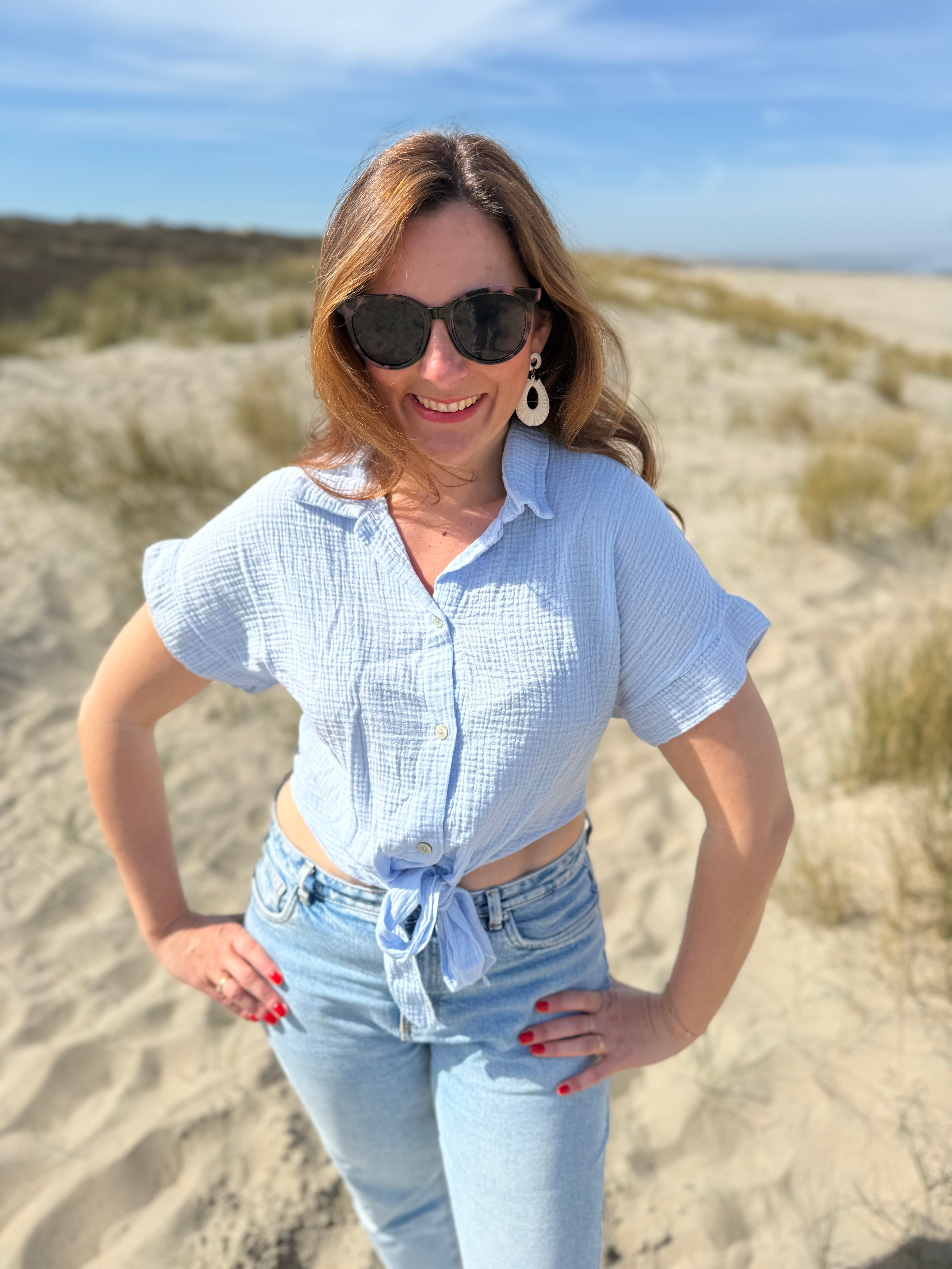 Musselinbluse in cropped Schnitt zum binden. Die Bluse hat kurze Flügelärmel und ist babyblau.