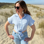 Musselinbluse in cropped Schnitt zum binden. Die Bluse hat kurze Flügelärmel und ist babyblau.