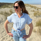 Musselinbluse in cropped Schnitt zum binden. Die Bluse hat kurze Flügelärmel und ist babyblau.