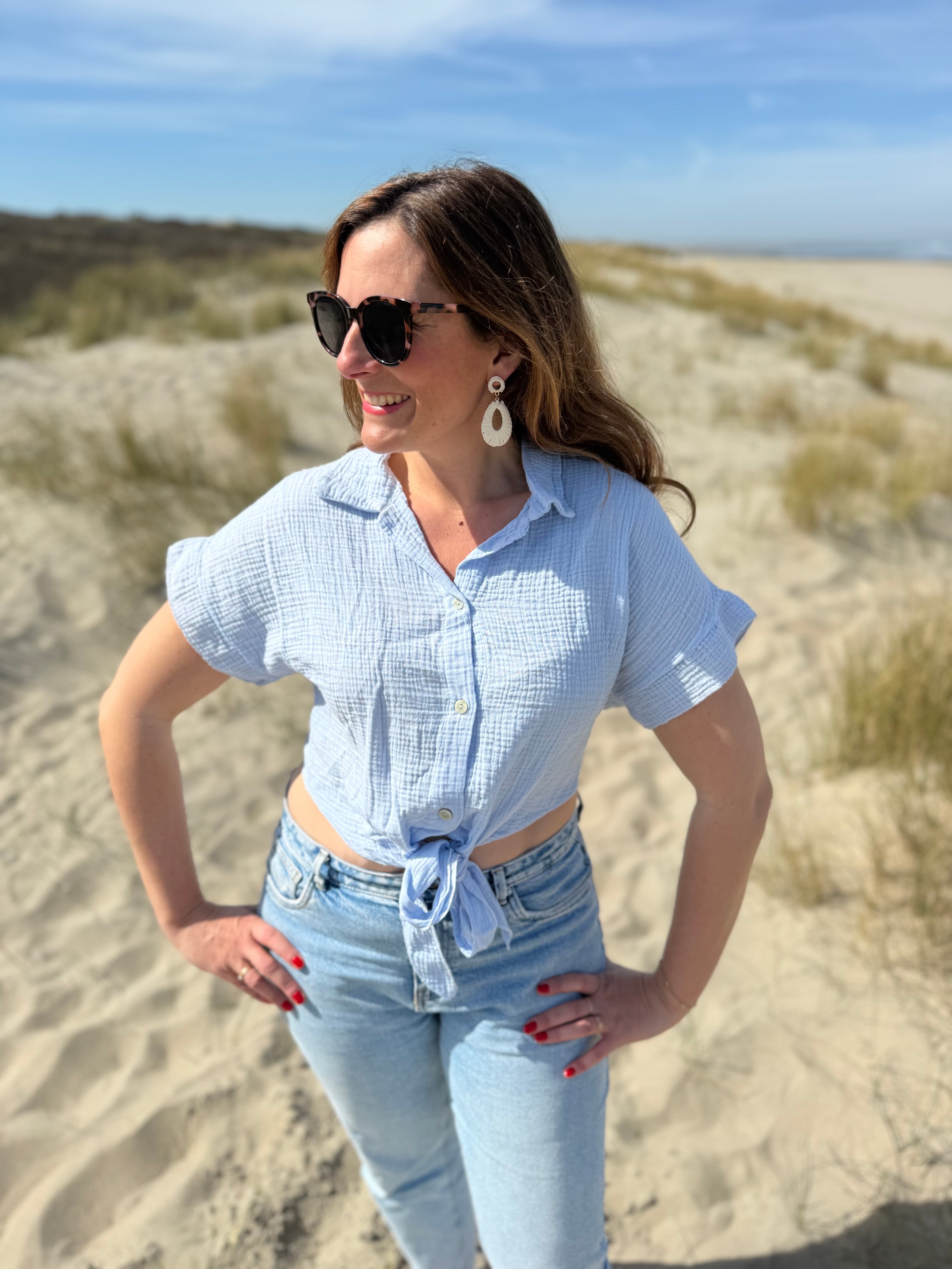 Musselinbluse in cropped Schnitt zum binden. Die Bluse hat kurze Flügelärmel und ist babyblau.