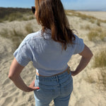 Musselinbluse in cropped Schnitt zum binden. Die Bluse hat kurze Flügelärmel und ist babyblau.