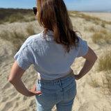 Musselinbluse in cropped Schnitt zum binden. Die Bluse hat kurze Flügelärmel und ist babyblau.