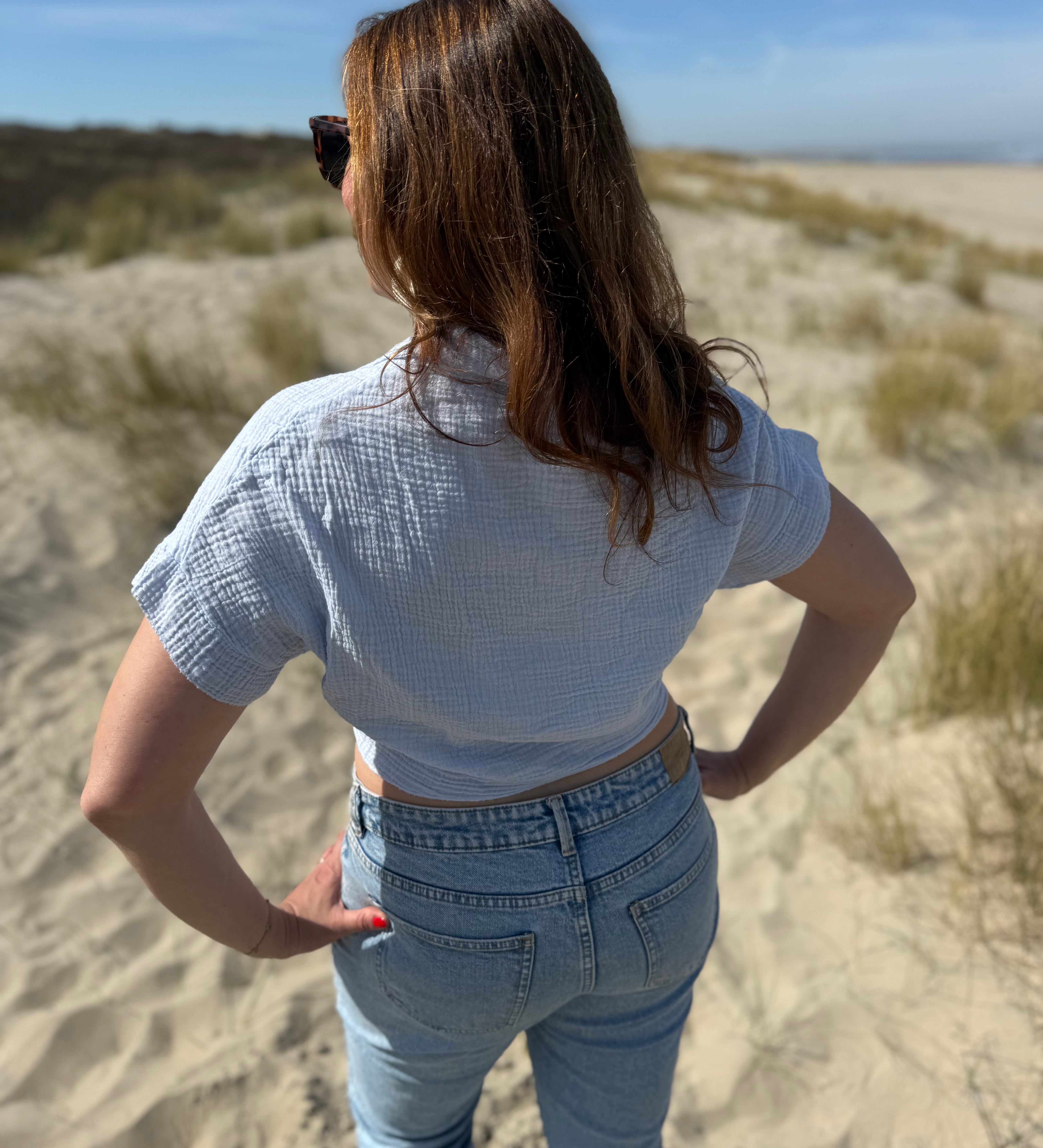 Musselinbluse in cropped Schnitt zum binden. Die Bluse hat kurze Flügelärmel und ist babyblau.