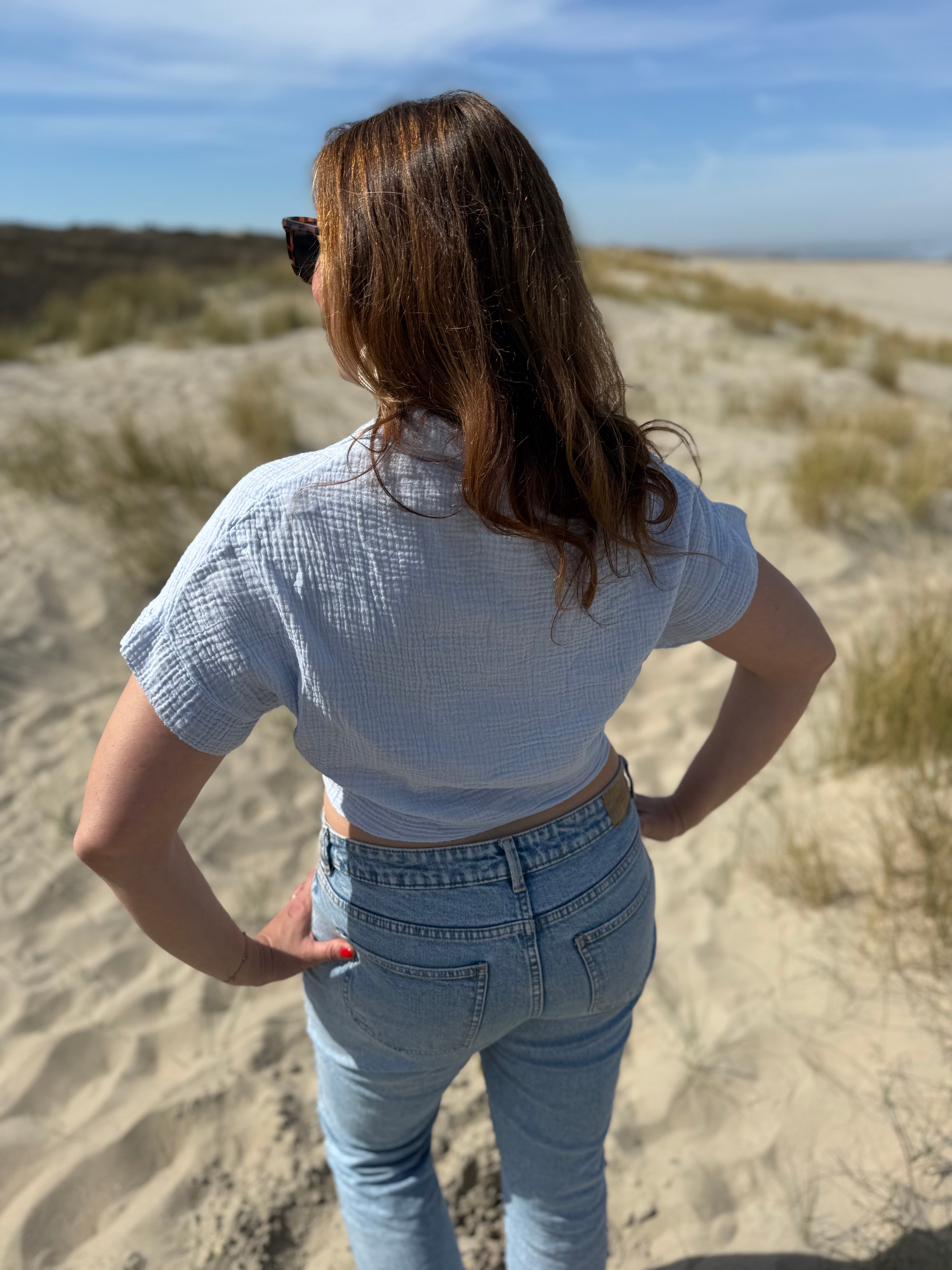 Musselinbluse in cropped Schnitt zum binden. Die Bluse hat kurze Flügelärmel und ist babyblau.