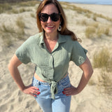 Musselinbluse in cropped Schnitt zum binden. Die Bluse hat kurze Flügelärmel und ist salbei grün.