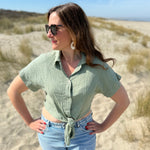 Musselinbluse in cropped Schnitt zum binden. Die Bluse hat kurze Flügelärmel und ist salbei grün.