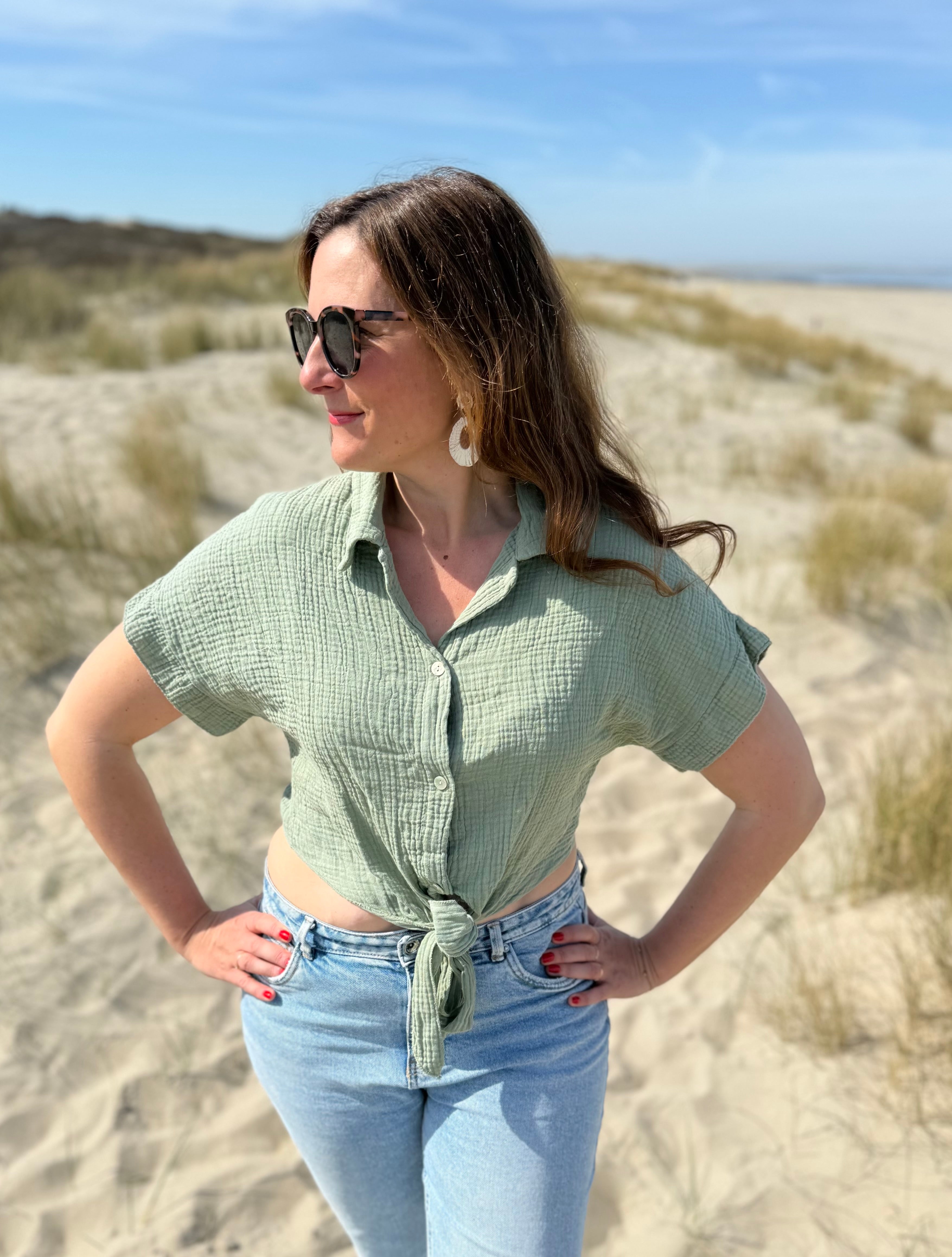 Musselinbluse in cropped Schnitt zum binden. Die Bluse hat kurze Flügelärmel und ist salbei grün.