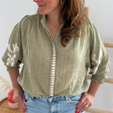 Leichte locker sitzende Baumwollbluse in salbei mit beigen Blumenstickereien an den Ärmeln.