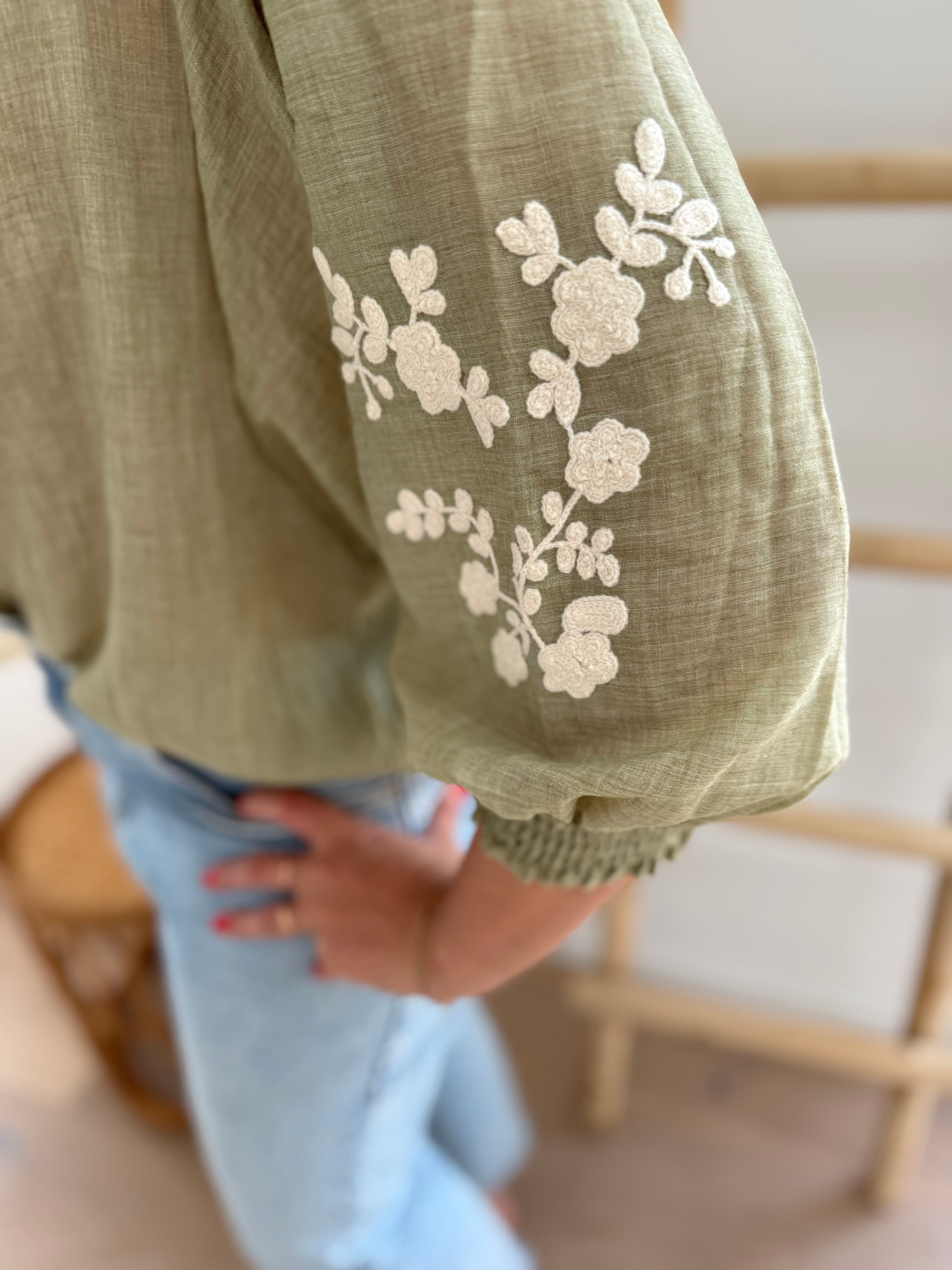 Leichte locker sitzende Baumwollbluse in salbei mit beigen Blumenstickereien an den Ärmeln.