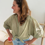 Leichte locker sitzende Baumwollbluse in salbei mit beigen Blumenstickereien an den Ärmeln.