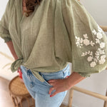 Leichte locker sitzende Baumwollbluse in salbei mit beigen Blumenstickereien an den Ärmeln.