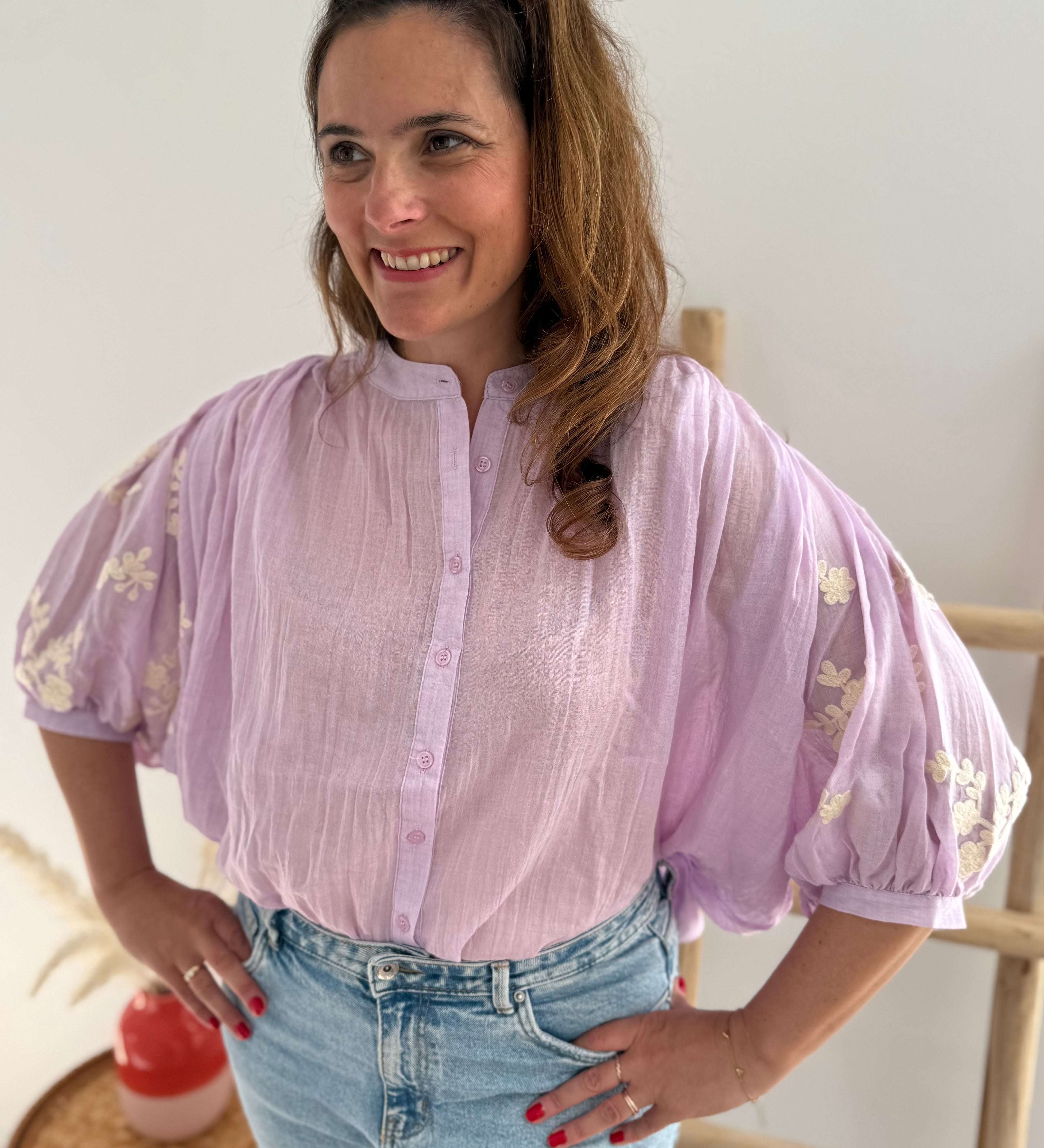 Leichte locker sitzende Baumwollbluse in flieder mit beigen Blumenstickereien an den Ärmeln.
