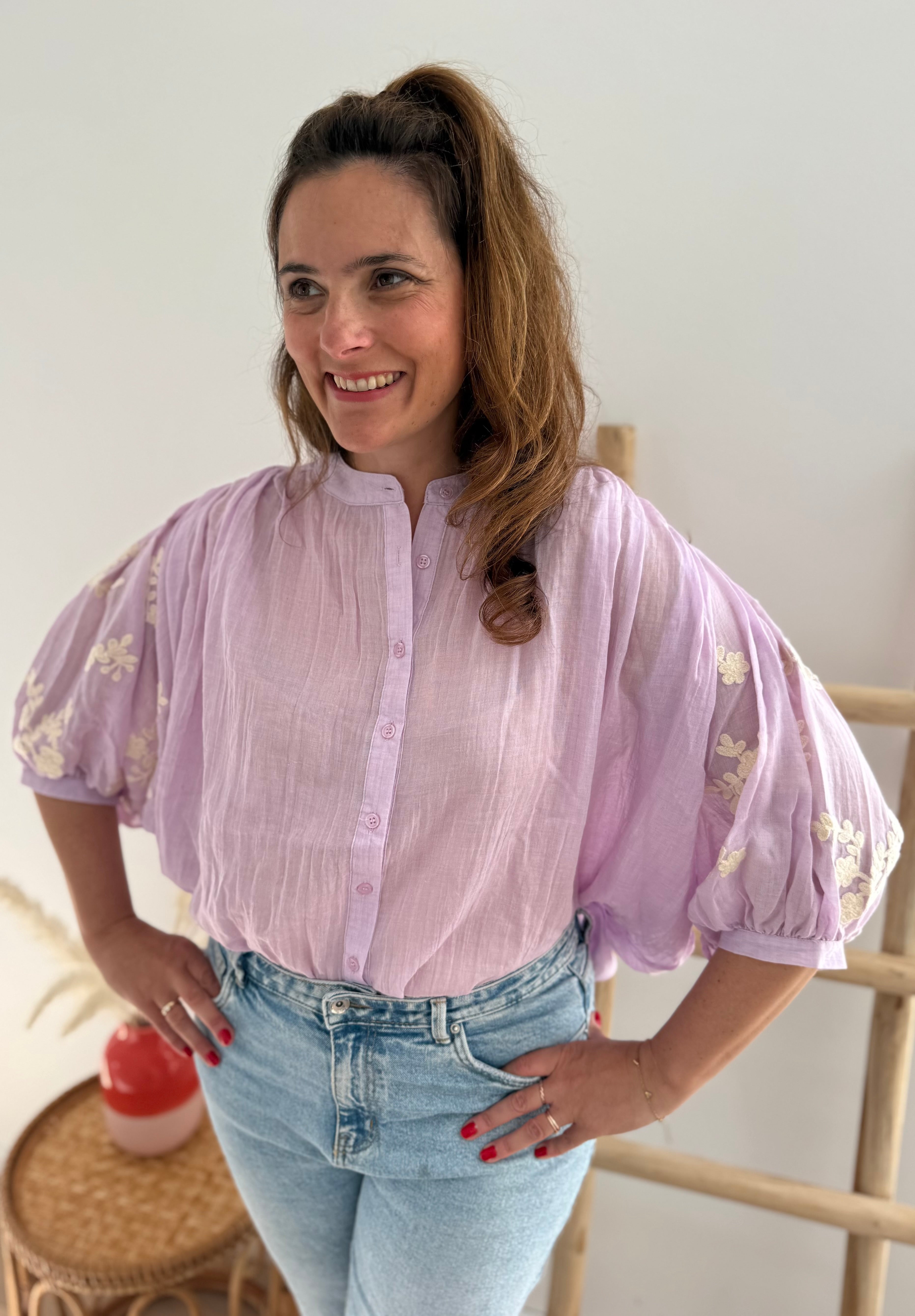Leichte locker sitzende Baumwollbluse in flieder mit beigen Blumenstickereien an den Ärmeln.
