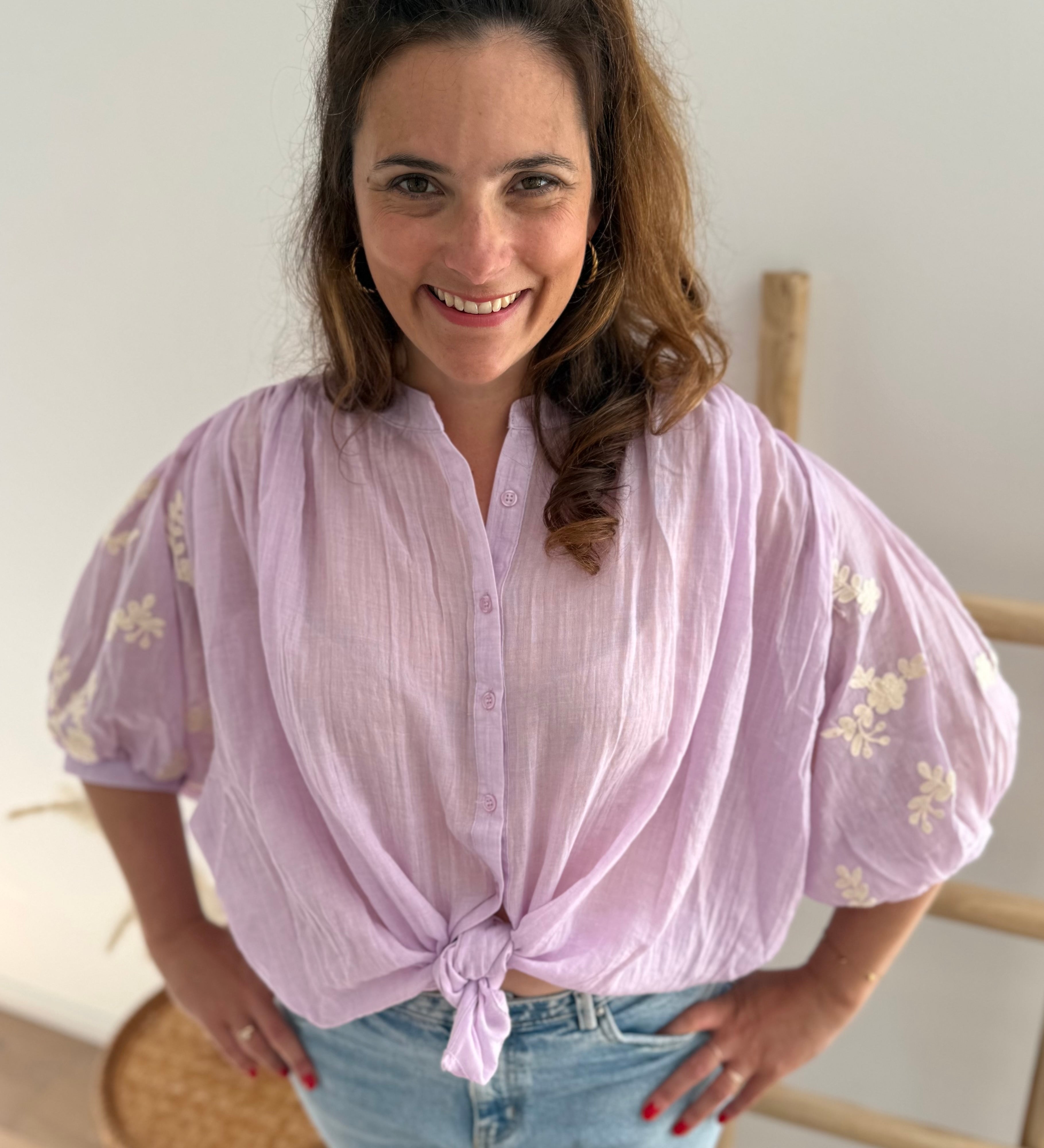 Leichte locker sitzende Baumwollbluse in flieder mit beigen Blumenstickereien an den Ärmeln.