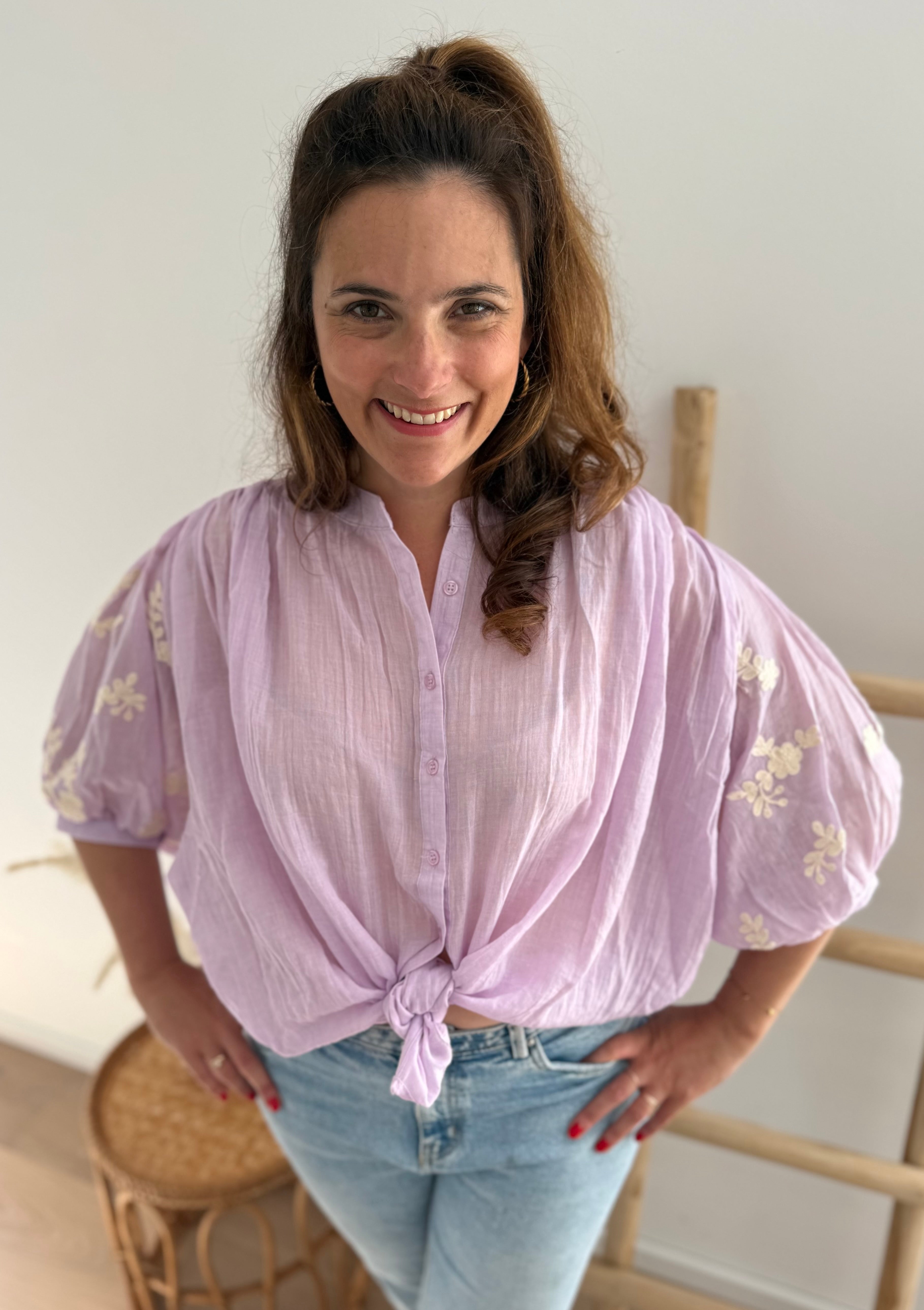 Leichte locker sitzende Baumwollbluse in flieder mit beigen Blumenstickereien an den Ärmeln.